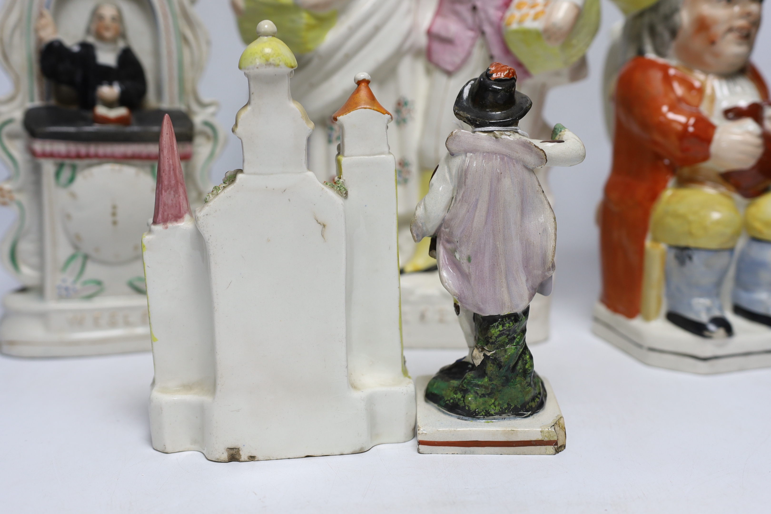 Seven 19th century Staffordshire figure groups including Orange Sellers and Wesley, together with a Toby jug, 35cm high